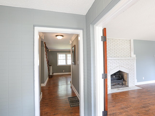 corridor featuring a textured ceiling and dark hardwood / wood-style flooring