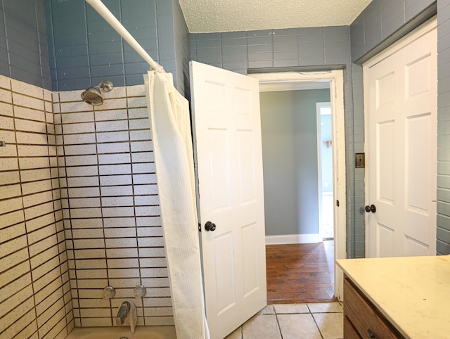 bathroom featuring a textured ceiling, shower / bath combo, and wood-type flooring