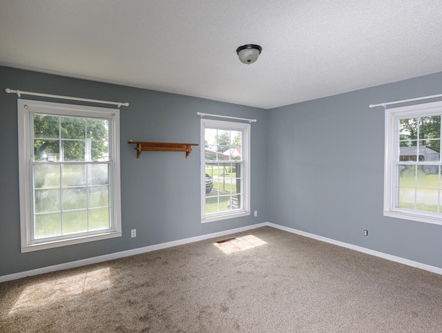 carpeted spare room featuring a textured ceiling