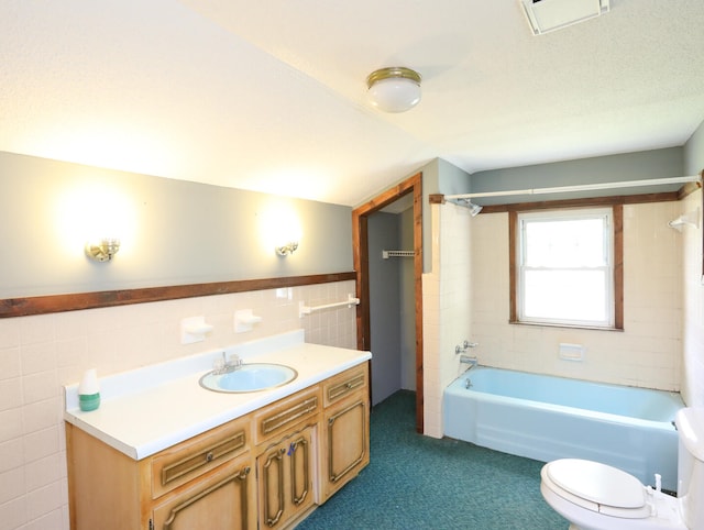 full bathroom featuring backsplash, vanity, tiled shower / bath, tile walls, and toilet