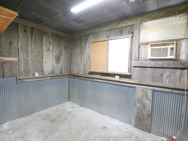 interior space featuring wooden walls, cooling unit, and concrete floors