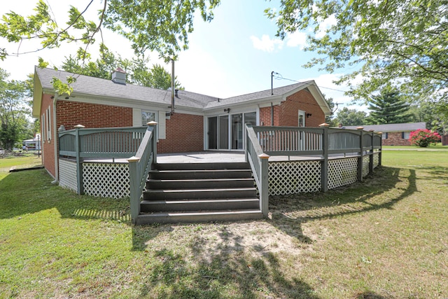 back of property with a deck and a yard