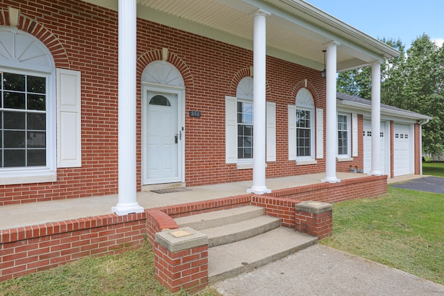 entrance to property featuring a garage and covered porch