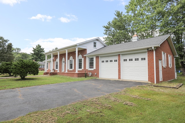 view of front of house featuring a porch, a garage, and a front lawn