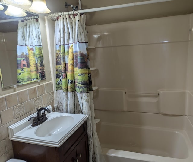 bathroom with tile walls, backsplash, vanity, and shower / bath combination with curtain