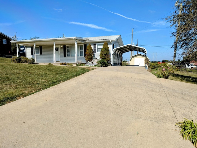 ranch-style home featuring a front lawn, a garage, an outbuilding, and a porch