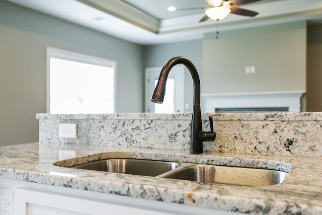 details featuring sink, ceiling fan, and light stone countertops