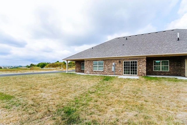 rear view of house with a lawn and a patio area