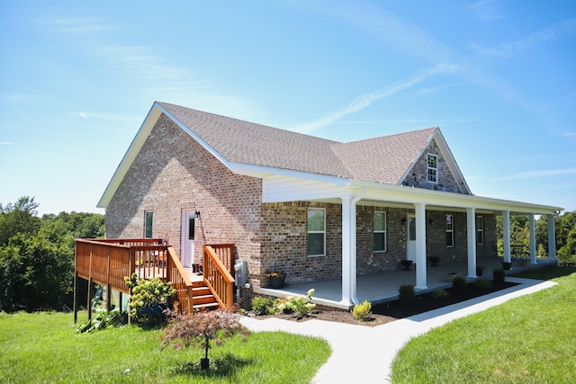 view of front of house with brick siding, roof with shingles, and a front yard