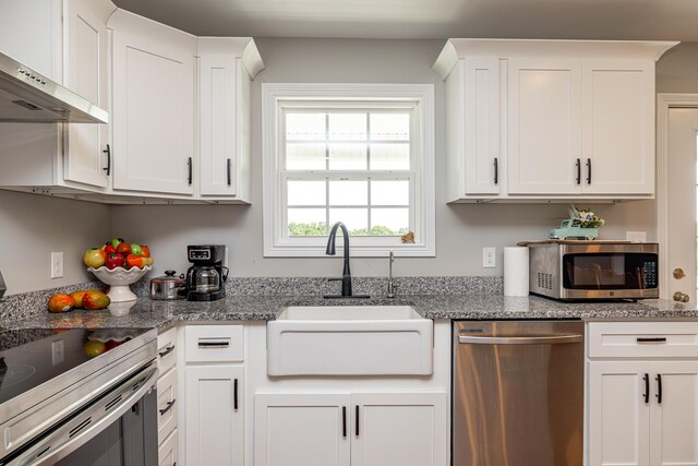 kitchen featuring sink, stone counters, white cabinetry, and appliances with stainless steel finishes