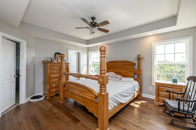 bedroom featuring ceiling fan, a tray ceiling, and hardwood / wood-style floors