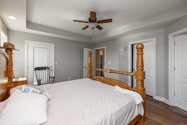 bedroom with recessed lighting, wood finished floors, a ceiling fan, baseboards, and a raised ceiling