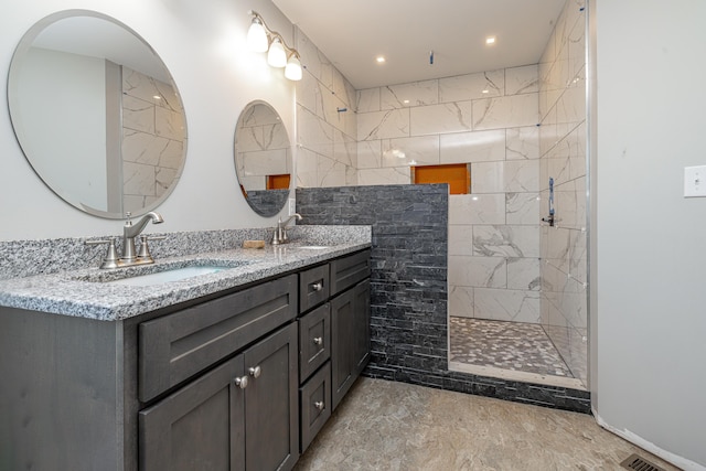 bathroom featuring double vanity, walk in shower, and a sink