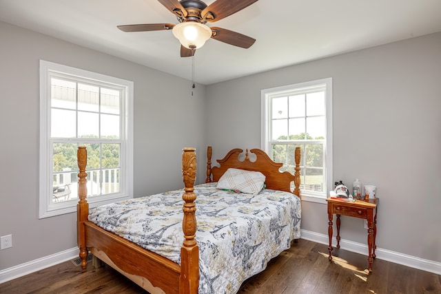 bedroom with a ceiling fan, multiple windows, dark wood finished floors, and baseboards