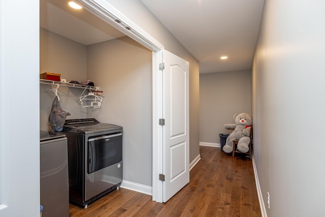 washroom with laundry area, separate washer and dryer, wood finished floors, and baseboards