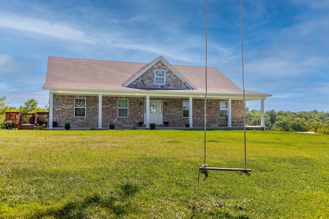 view of front of house featuring brick siding, a shingled roof, and a front yard