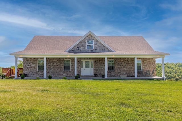 view of front of home featuring a porch, roof with shingles, a front yard, and brick siding