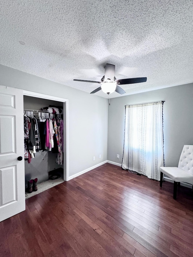 unfurnished bedroom with a textured ceiling, a closet, ceiling fan, and hardwood / wood-style flooring