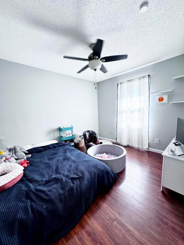 bedroom featuring ceiling fan, hardwood / wood-style flooring, and a textured ceiling