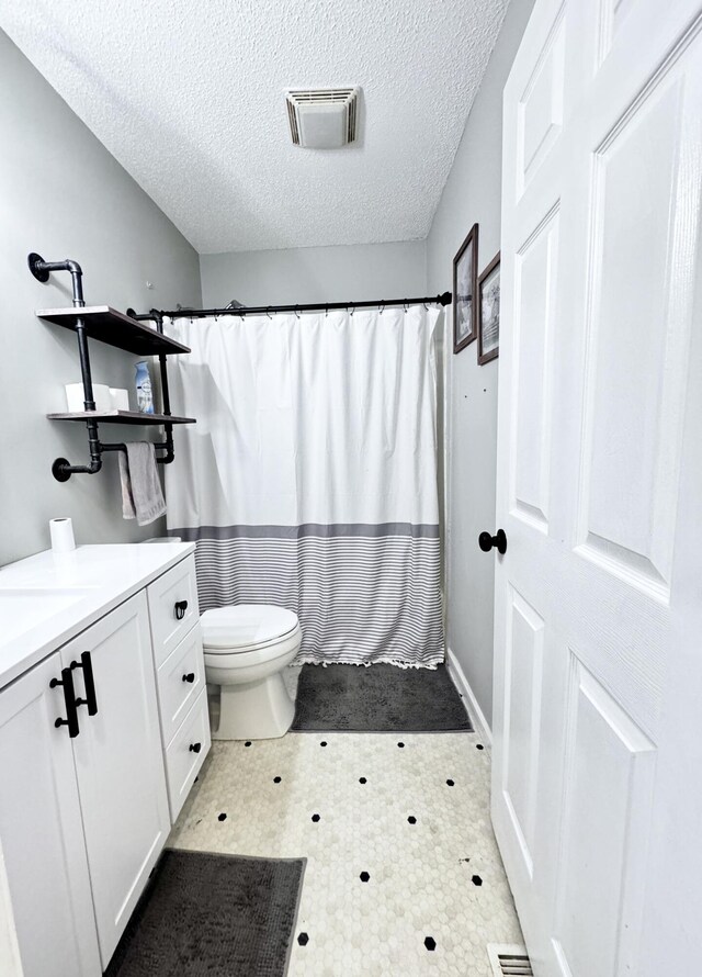 231 Hatfield St, Corbin, KY 40701 - bathroom featuring toilet, tile patterned floors, a textured ceiling, curtained shower, and vanity