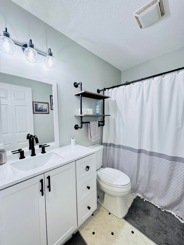 bathroom featuring a textured ceiling, vanity, and toilet