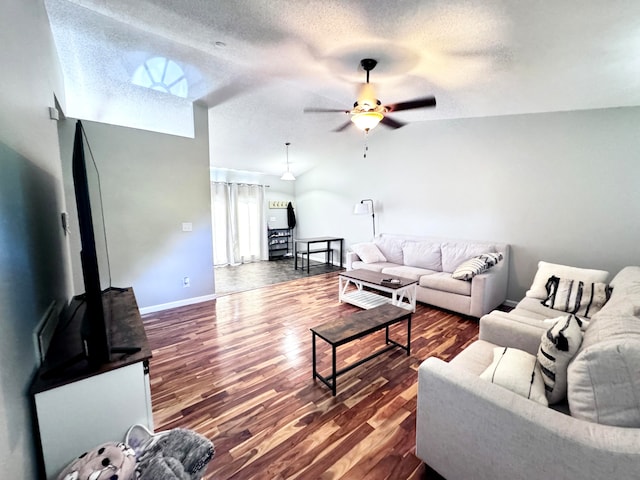 living room with a textured ceiling, ceiling fan, vaulted ceiling, and wood-type flooring