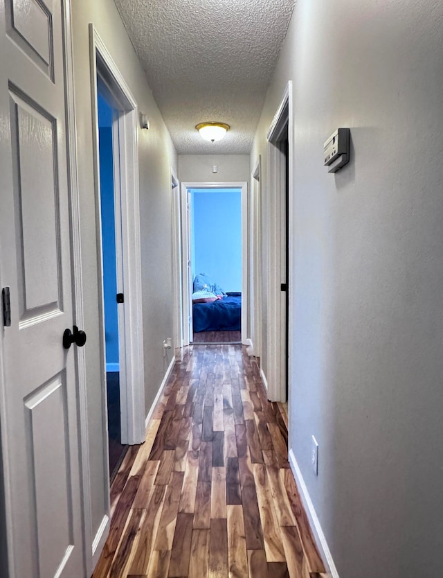 hallway featuring a textured ceiling and wood-type flooring