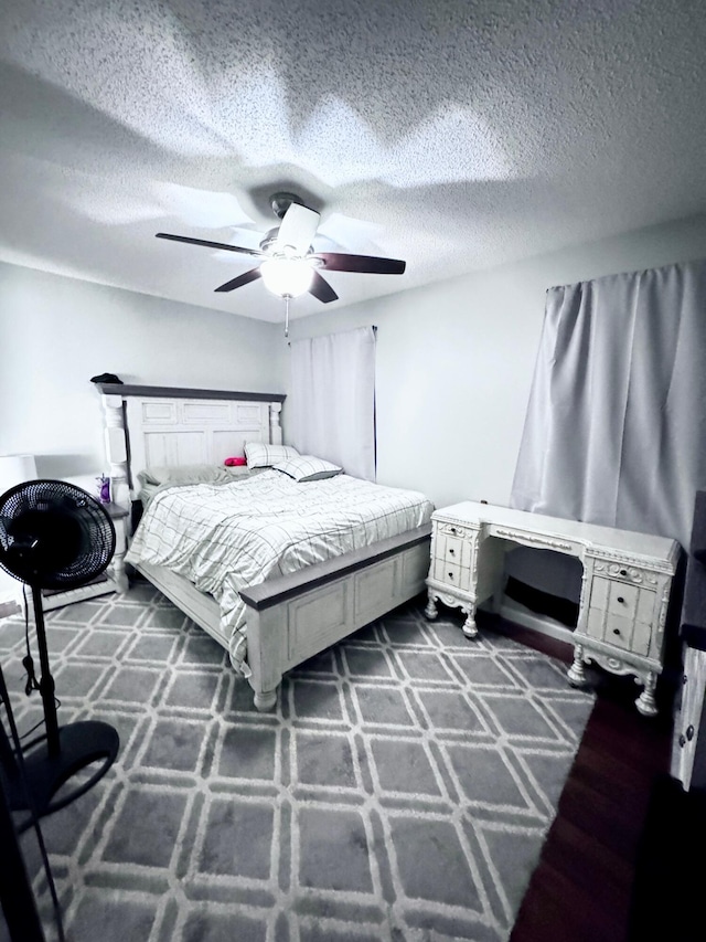 bedroom with ceiling fan and a textured ceiling