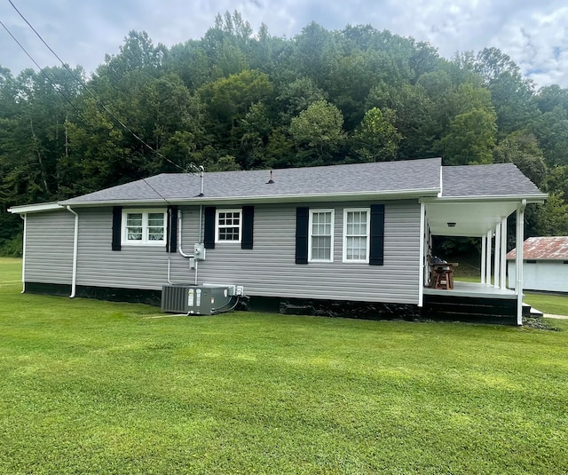 back of house featuring a yard and central AC