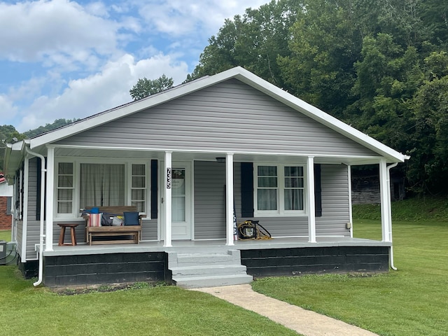 bungalow-style home with a front yard and covered porch