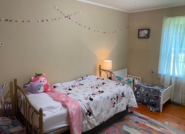 bedroom featuring hardwood / wood-style flooring and ornamental molding