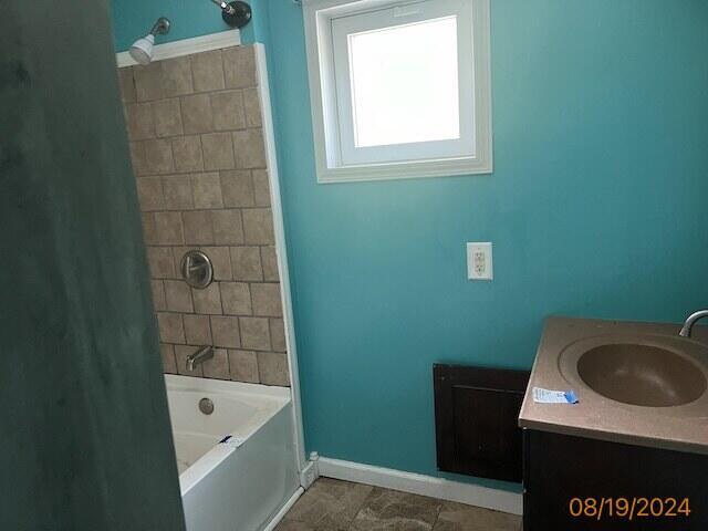 bathroom with tile patterned flooring, vanity, and tiled shower / bath combo