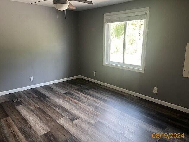 unfurnished room with ceiling fan and dark hardwood / wood-style flooring