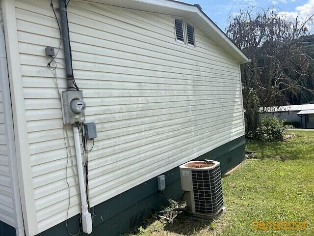 view of property exterior with a yard and central AC