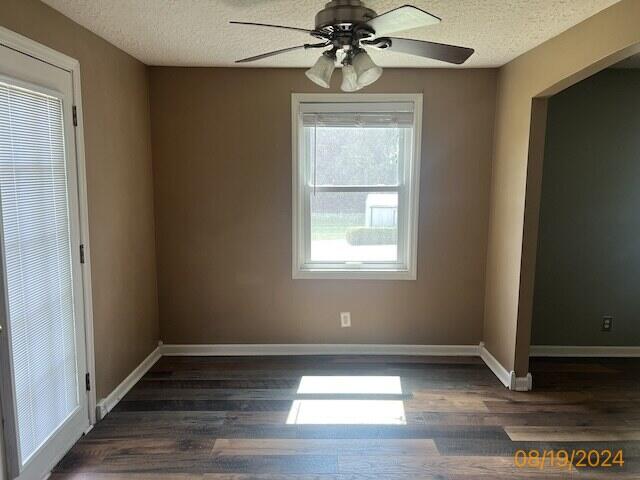 unfurnished room featuring a textured ceiling, ceiling fan, and dark hardwood / wood-style flooring