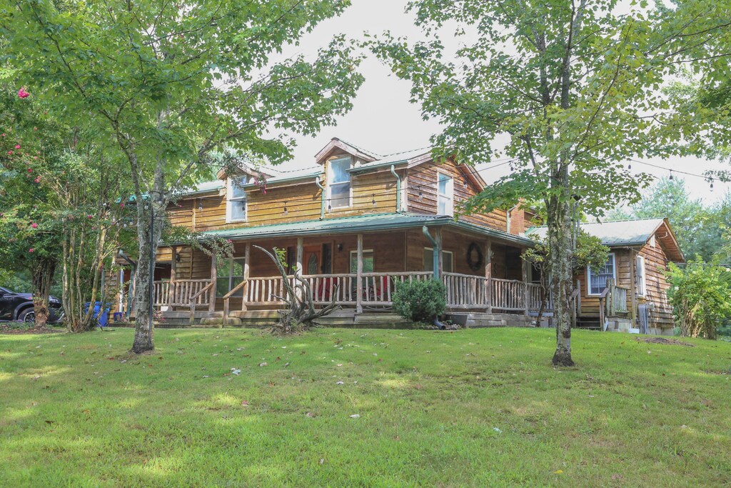 log home featuring a front lawn and a porch