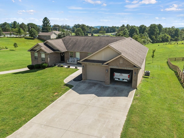 ranch-style home featuring a garage, central AC, and a front yard