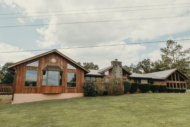 back of property featuring a yard and a chimney