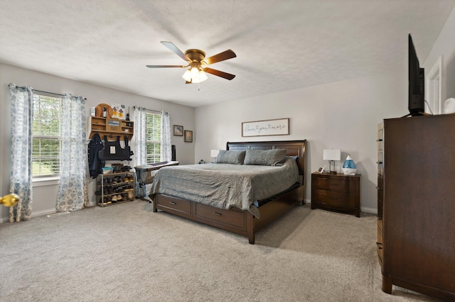 carpeted bedroom featuring ceiling fan and a textured ceiling