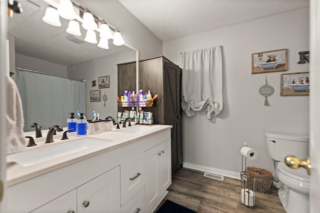 bathroom with hardwood / wood-style flooring, vanity, and toilet