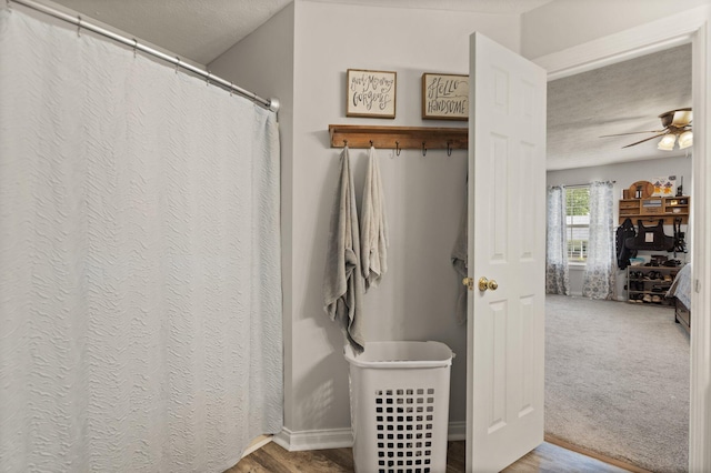 bathroom with ceiling fan and a textured ceiling