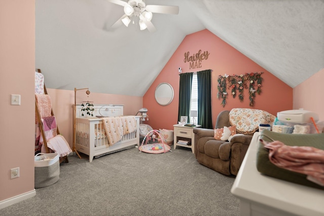 carpeted bedroom featuring ceiling fan, a nursery area, and lofted ceiling