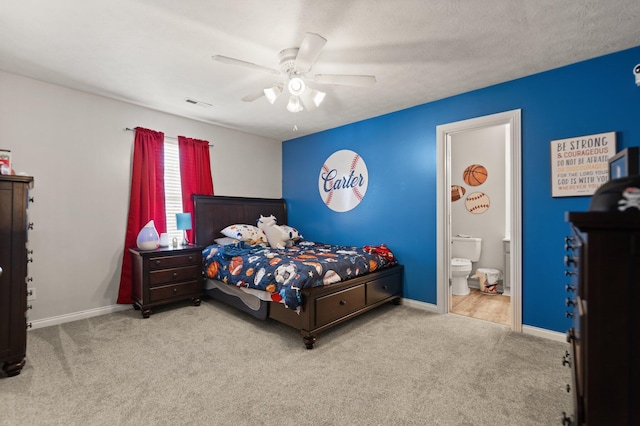 bedroom with ceiling fan, light carpet, and ensuite bath