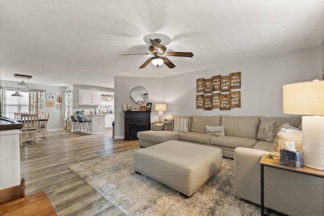 living room with ceiling fan and dark hardwood / wood-style floors