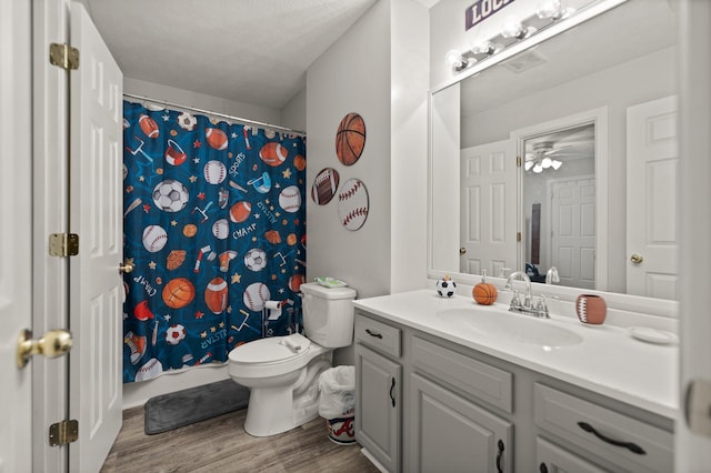 bathroom with hardwood / wood-style floors, a textured ceiling, a shower with shower curtain, vanity, and toilet