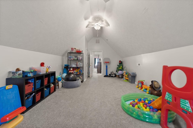 rec room with a textured ceiling, carpet floors, ceiling fan, and vaulted ceiling