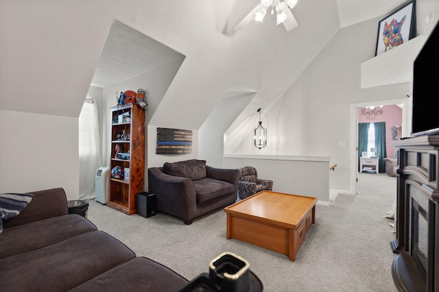 living room featuring carpet flooring, lofted ceiling, and ceiling fan with notable chandelier