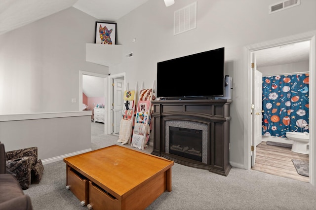 living room with hardwood / wood-style flooring and high vaulted ceiling