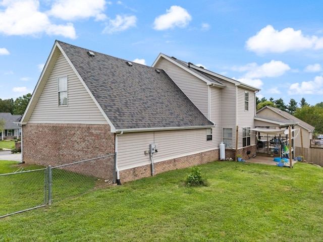 view of side of home featuring a lawn and a patio