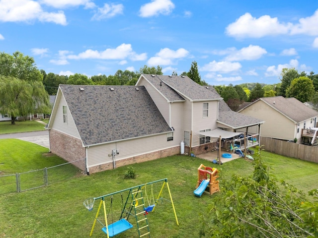 rear view of house featuring a playground and a yard